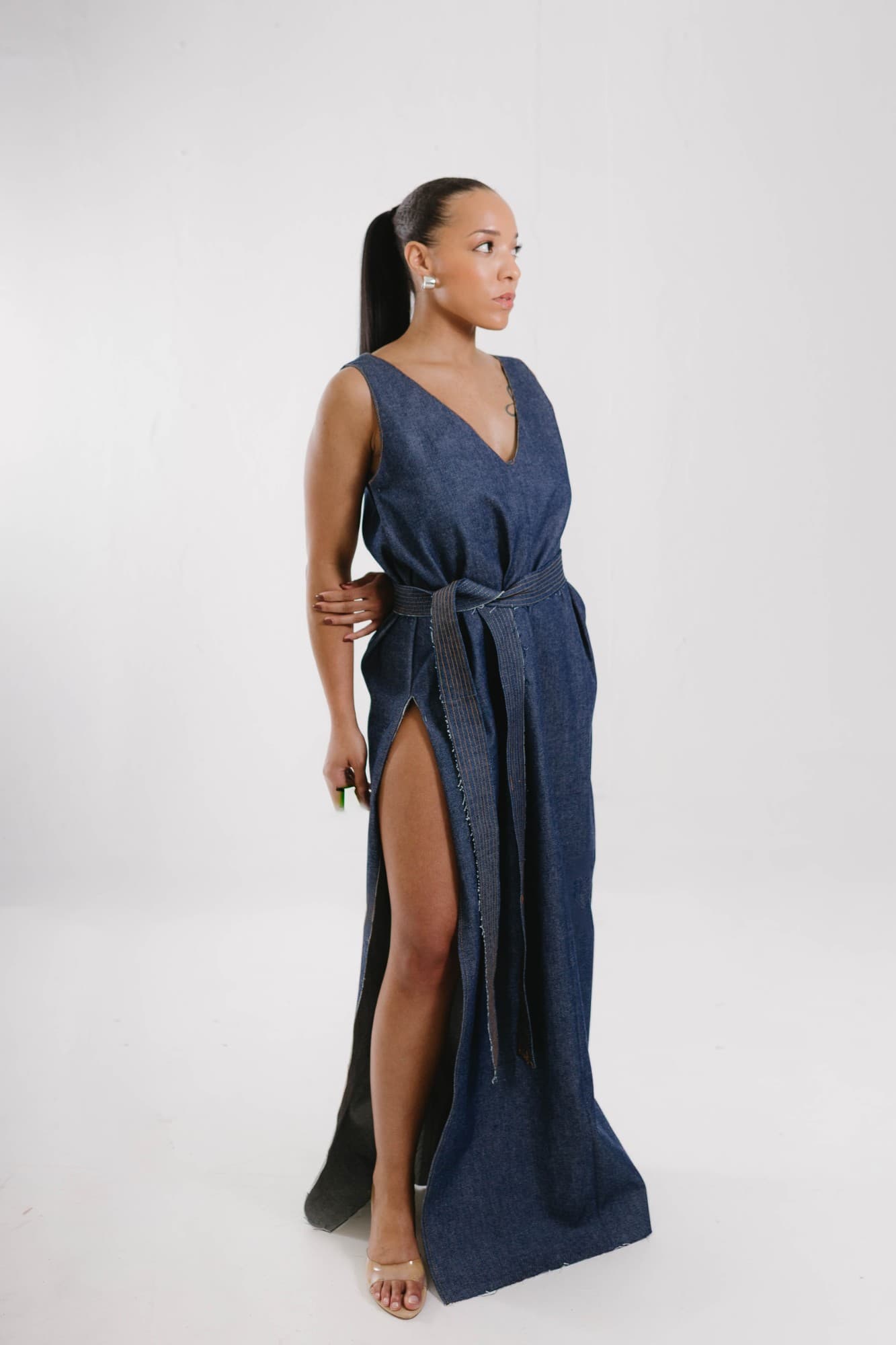 the signature, sleeveless denim gown with tie belt and high slit